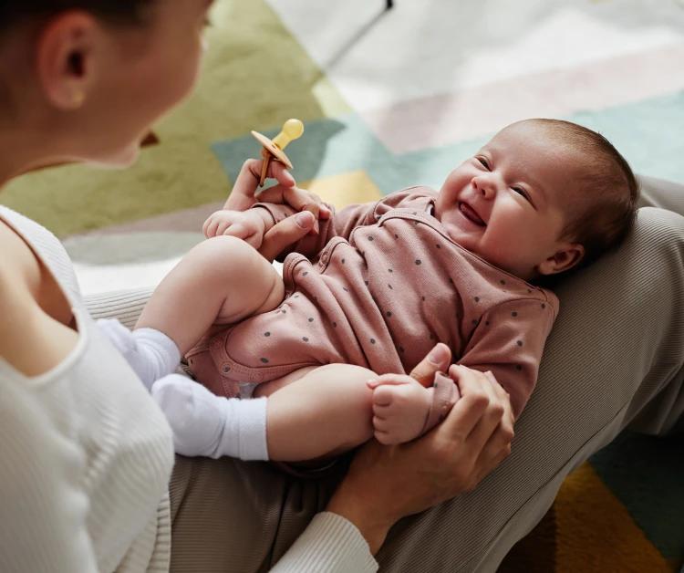 Baby joyfully smiling at her mom