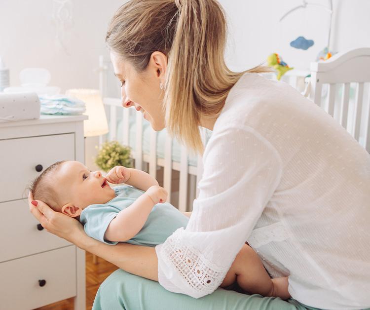 Mom holding baby in nursery
