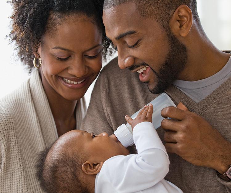 Mamá alimenta con biberón a su bebé que la está mirando
