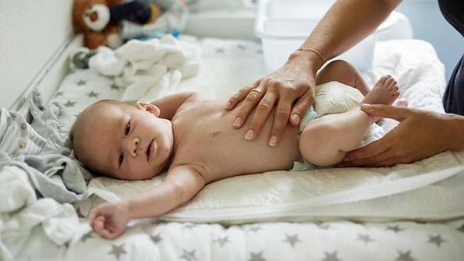 Mamá colocando su mano sobre el estómago del bebé.