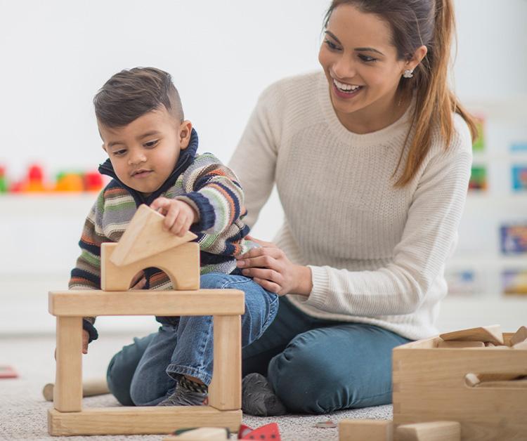 Mom and toddler son playing with blocks
