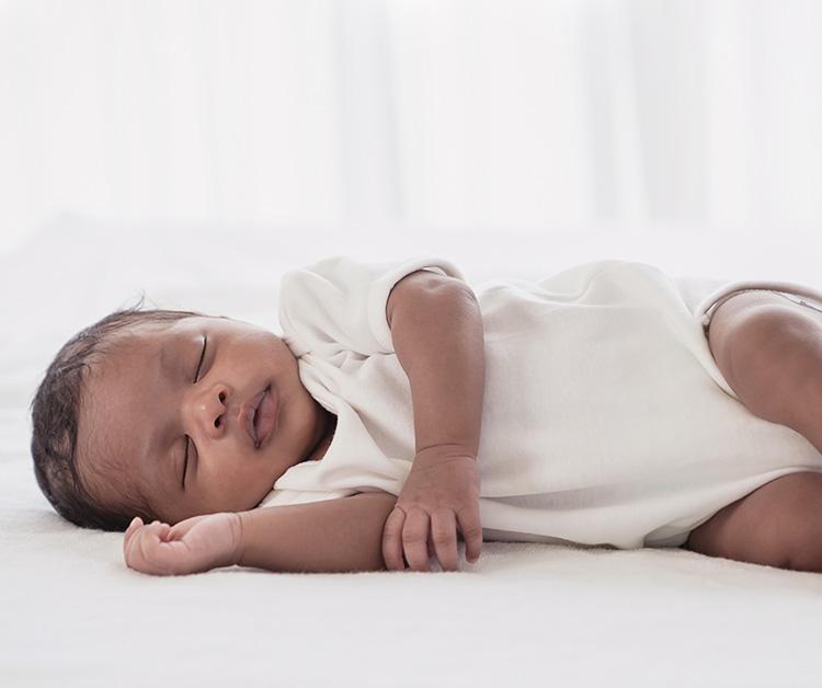 Baby sleeping in a clear bassinet