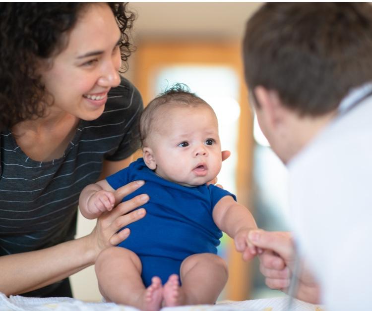 Mom and baby visiting with a pediatrician