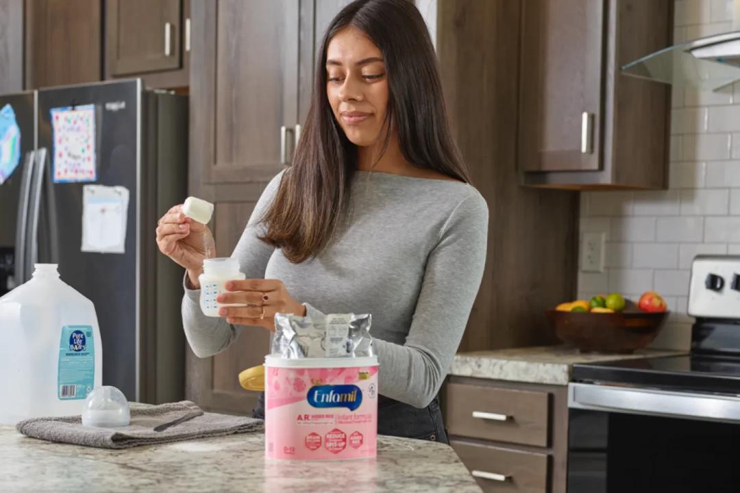 Erin Andrews holding her son with Enfamil Enspire™ Optimum Infant Formula, follow label instructions for preparation and storage