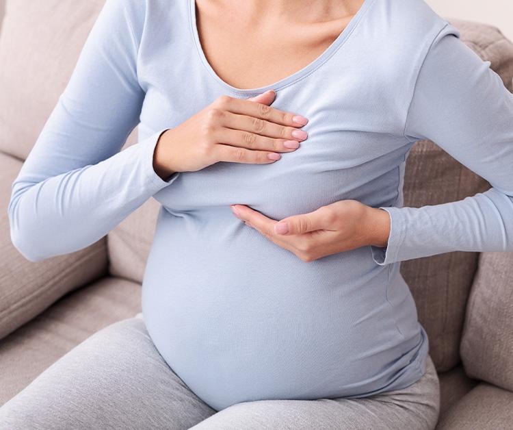 Pregnant woman pressing on breast