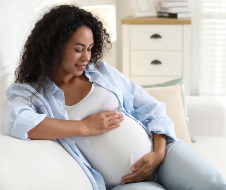 Una madre embarazada sentada en el sofá