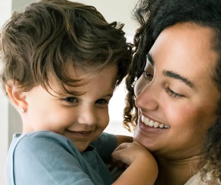 Mamá sonriendo y sosteniendo al niño