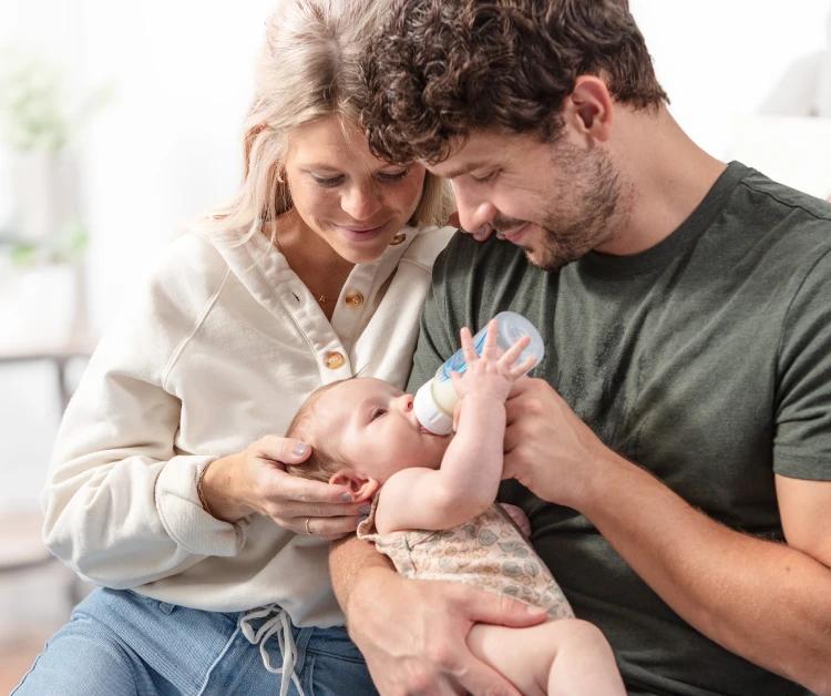 Mom and dad feeding baby a bottle