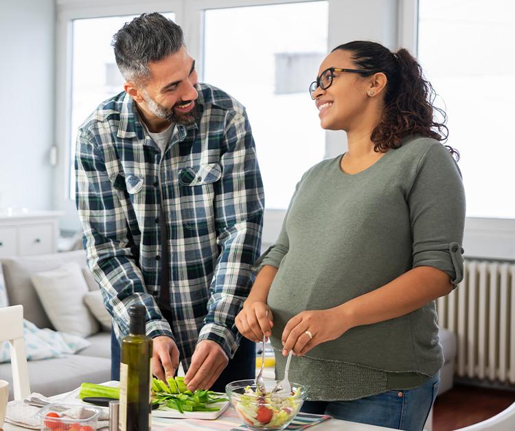 Pregnant mom and dad making dinner together