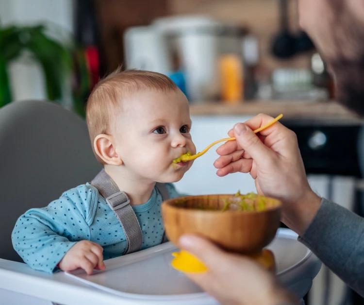 Parent spoon-feeding baby