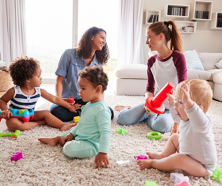 Two mom friends talking while their children play
