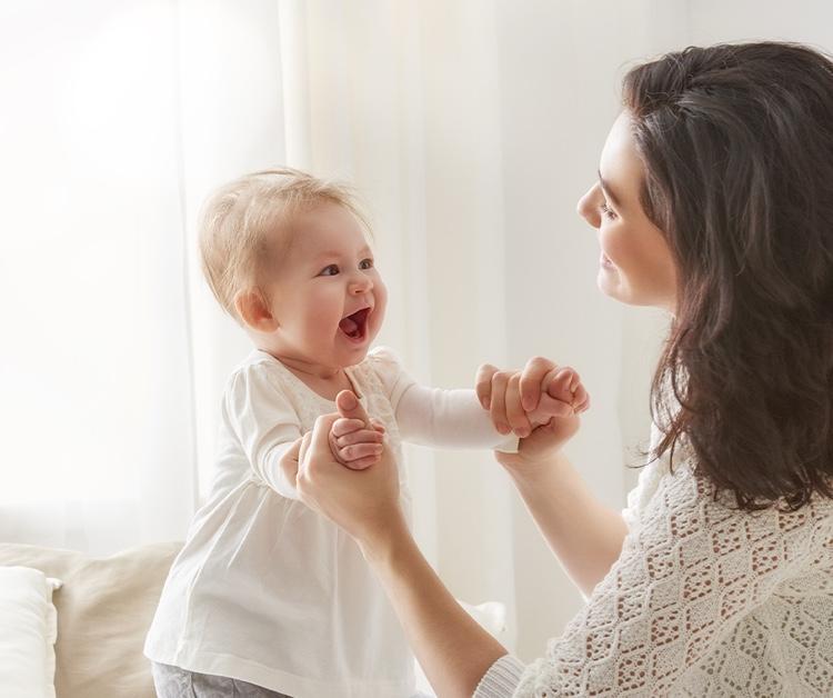 Madre tomando de la mano a su bebé