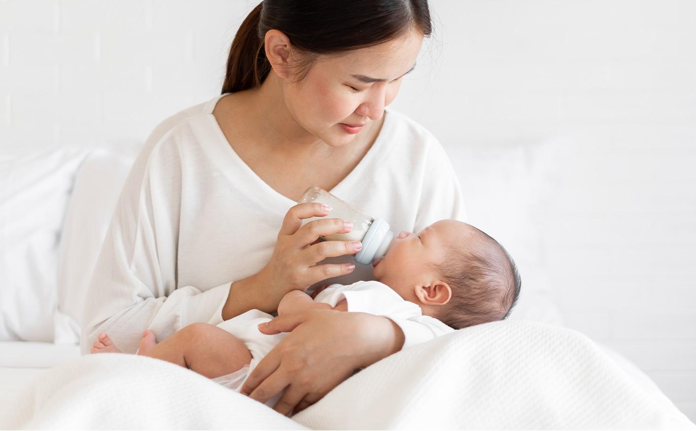 Mom cradling baby and bottle feeding