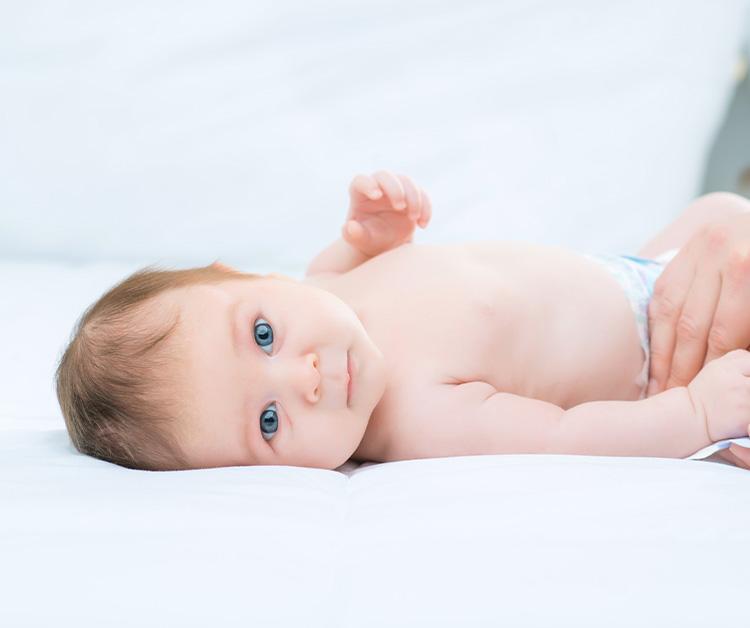 Blue eyed baby getting a diaper change