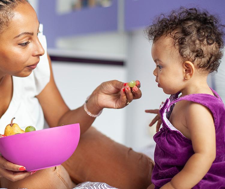 Mom feeding her toddler girl