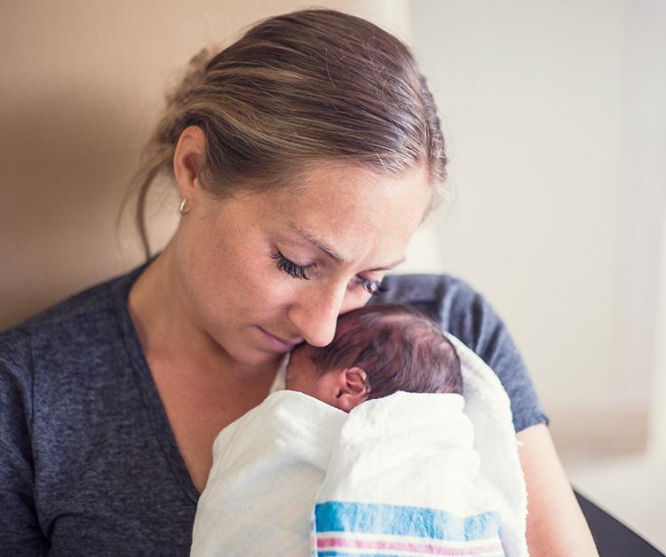 Mom holding newborn baby close