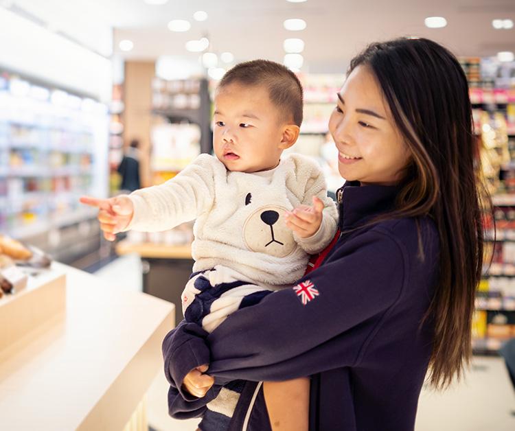 Madre haciendo un gesto a su bebé en la cuna