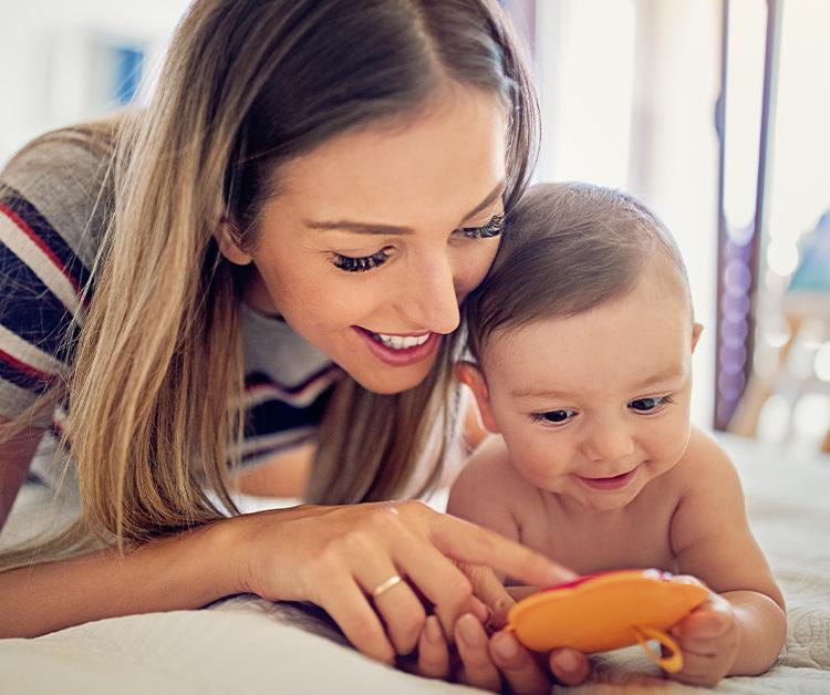 Mom showing baby how to use toy
