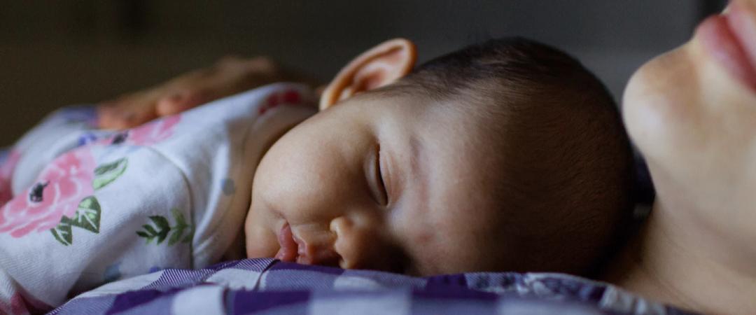 Mom holding infant at night