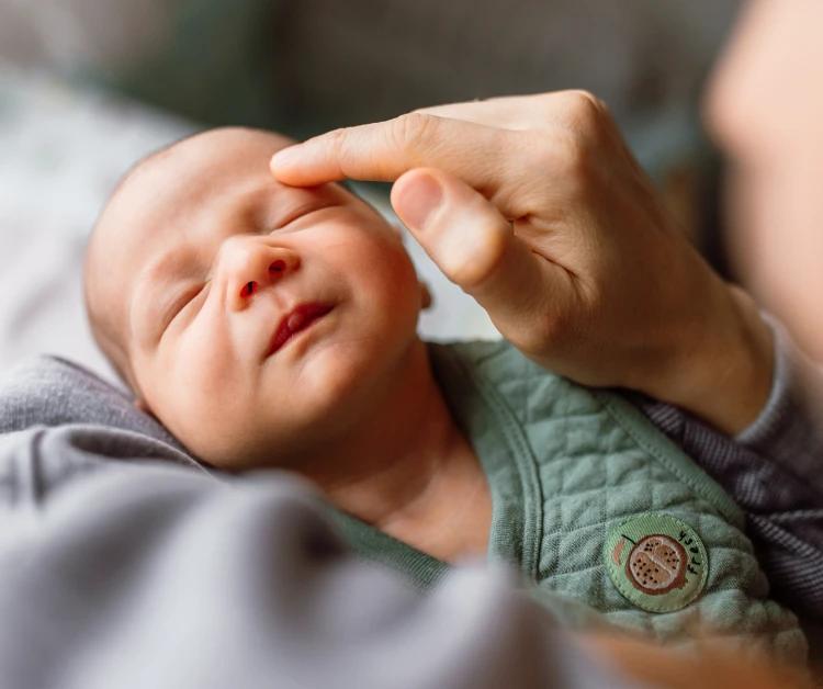 Parent holding a sleeping newborn