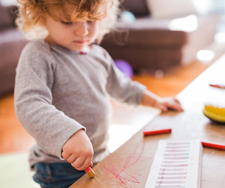 Toddler marking on coffee table with crayons