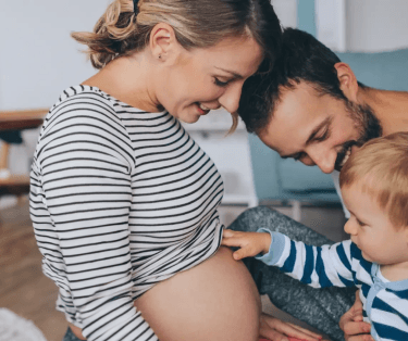 Mamá colocando su mano sobre el estómago del bebé.