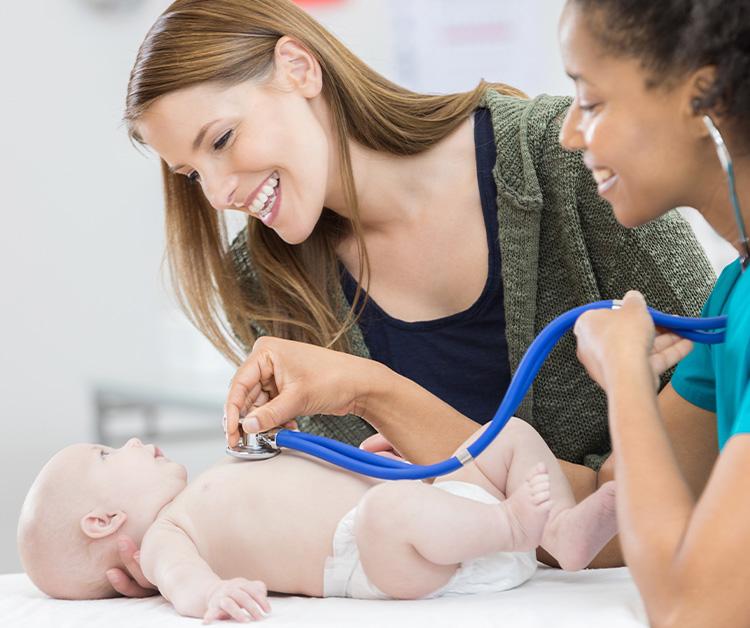 Mom and nurse smiling at baby in pediatrician's office