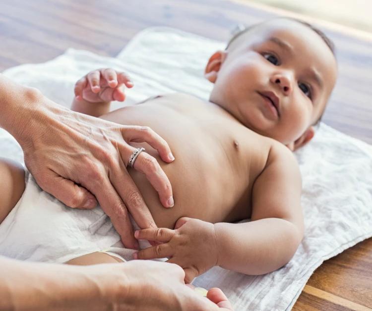 Newborn smiling as parent put hands on their belly