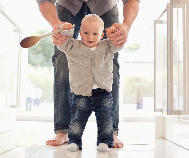 Dad helping his son walk