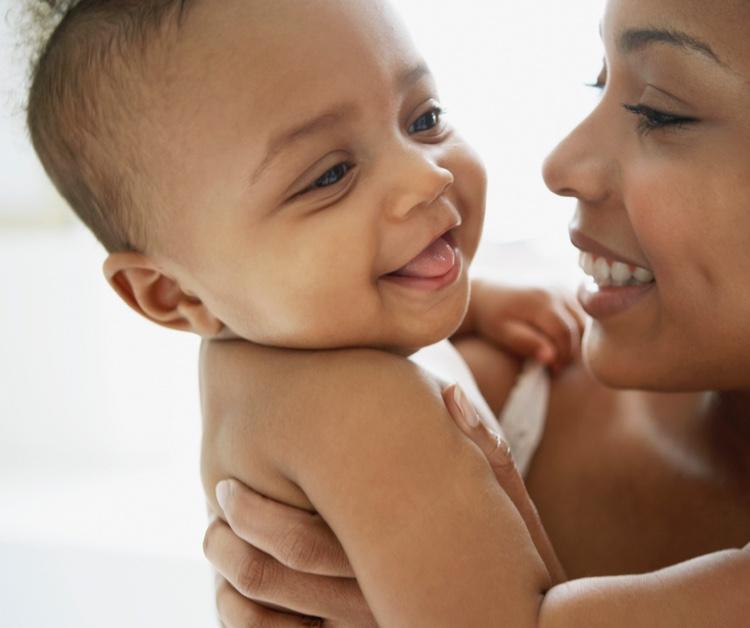 Mom holding infant and smiling
