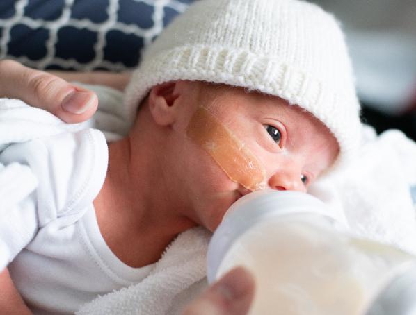 Niña tirada en el suelo con un animal de peluche mirando a su mamá