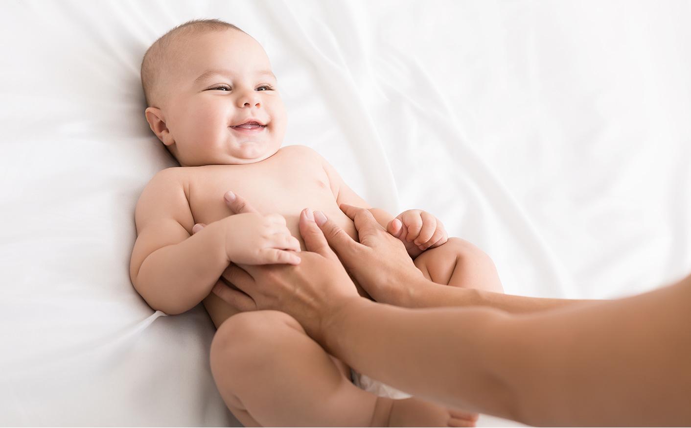 Newborn smiling as parent put hands on their belly