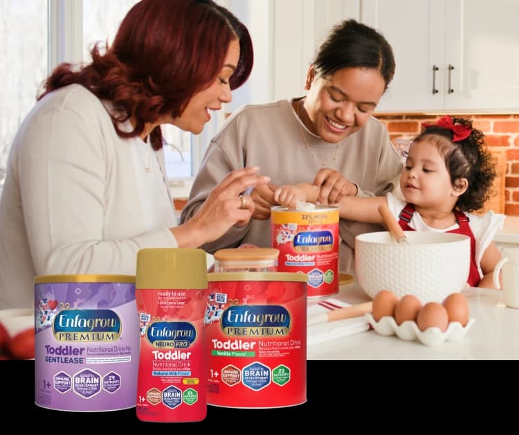 Mom, grandmother, and toddler in the kitchen with a lineup of toddler nutritional drinks