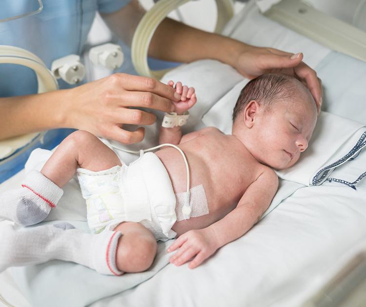 Newborn preemie being cared for in the NICU