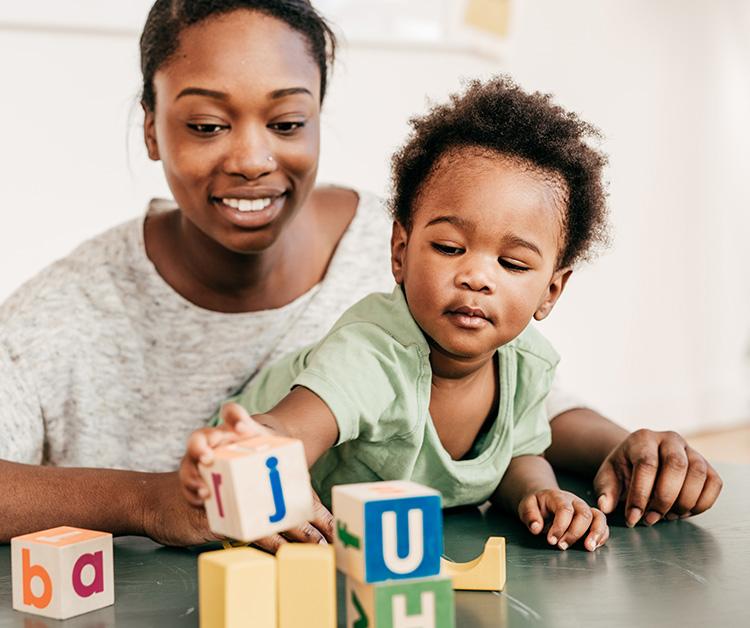 Mamá y niño jugando con bloques con letras