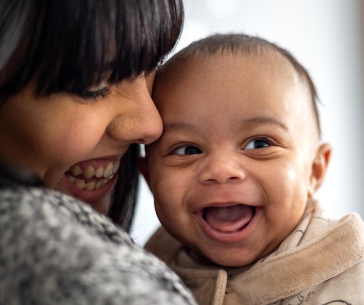 Mom holding smiling baby